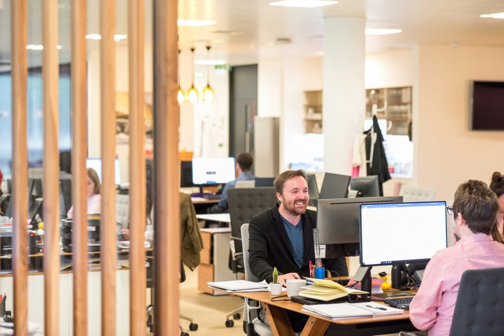 A couple of people smiling in an office environment